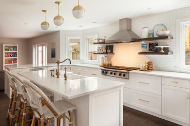 Open concept kitchen - mid-sized transitional u-shaped dark wood floor and brown floor open concept kitchen idea in Portland with a farmhouse sink, shaker cabinets, white cabinets, quartz countertops, white backsplash, subway tile backsplash, stainless steel appliances, an island and white countertops