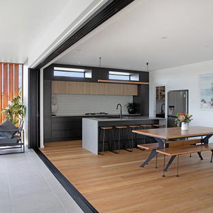 This is an example of a contemporary kitchen in Central Coast with flat-panel cabinets, subway tile splashback, with island and grey benchtop.