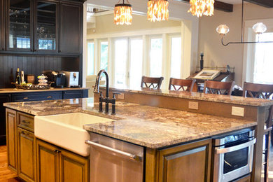 Open concept kitchen - large traditional u-shaped medium tone wood floor and brown floor open concept kitchen idea in Atlanta with a farmhouse sink, recessed-panel cabinets, dark wood cabinets, granite countertops, brown backsplash, wood backsplash, stainless steel appliances and an island