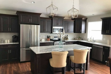 Example of a large transitional l-shaped dark wood floor and brown floor eat-in kitchen design in Other with a double-bowl sink, recessed-panel cabinets, dark wood cabinets, granite countertops, stainless steel appliances, an island and gray countertops
