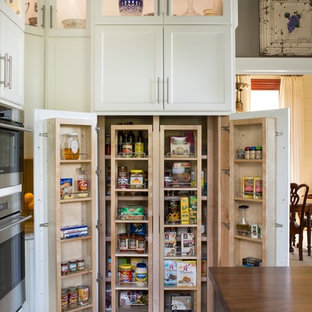 Große Landhausstil Küche mit Landhausspüle, Schrankfronten im Shaker-Stil, weißen Schränken, Kalkstein-Arbeitsplatte, Küchengeräten aus Edelstahl, braunem Holzboden, Kücheninsel und Vorratsschrank in Atlanta