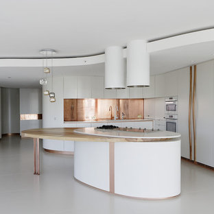 Diseño de cocina en L, minimalista, grande, abierta, con fregadero bajoencimera, armarios con paneles lisos, puertas de armario blancas, encimera de acrílico, salpicadero metalizado, salpicadero de metal, electrodomésticos blancos, suelo de baldosas de cerámica, una isla y suelo beige
