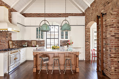 Example of a farmhouse l-shaped dark wood floor eat-in kitchen design in Nashville with shaker cabinets, white cabinets, red backsplash, brick backsplash, paneled appliances and an island