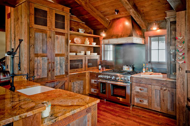 Medium sized rustic u-shaped open plan kitchen in Denver with a belfast sink, shaker cabinets, medium wood cabinets, medium hardwood flooring, a breakfast bar, granite worktops and integrated appliances.