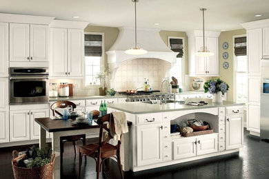 Example of a large transitional kitchen design in Other with an undermount sink, raised-panel cabinets, white cabinets, quartz countertops, white backsplash, ceramic backsplash, stainless steel appliances and an island