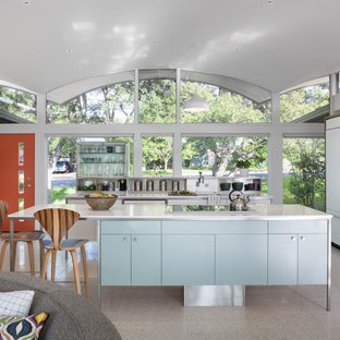 Idee per una cucina minimalista di medie dimensioni con lavello sottopiano, ante lisce, ante bianche, elettrodomestici da incasso, isola e pavimento alla veneziana