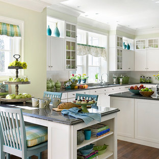 Inspiration for a large timeless u-shaped medium tone wood floor open concept kitchen remodel in Boston with an undermount sink, recessed-panel cabinets, white cabinets, granite countertops, white backsplash, subway tile backsplash, paneled appliances and an island