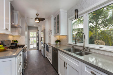 Inspiration for a mid-sized craftsman galley porcelain tile and gray floor enclosed kitchen remodel in Other with an undermount sink, shaker cabinets, white cabinets, quartz countertops, white backsplash, ceramic backsplash, stainless steel appliances, no island and gray countertops