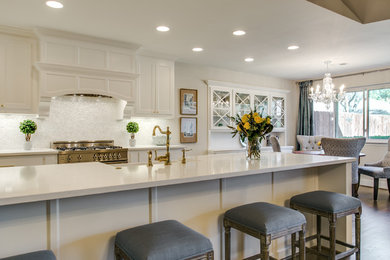 Example of a mid-sized transitional galley medium tone wood floor kitchen design in Dallas with a farmhouse sink, shaker cabinets, white cabinets, quartz countertops, white backsplash, mosaic tile backsplash, stainless steel appliances and a peninsula