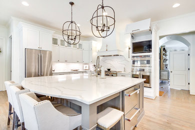 Inspiration for a large eclectic u-shaped eat-in kitchen remodel in Birmingham with shaker cabinets, white cabinets, quartz countertops, white backsplash, stainless steel appliances, an island and white countertops