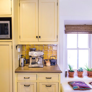 Design ideas for a mid-sized traditional u-shaped separate kitchen in Albuquerque with a farmhouse sink, shaker cabinets, yellow cabinets, concrete benchtops, yellow splashback, ceramic splashback, stainless steel appliances, dark hardwood floors, with island and brown floor.