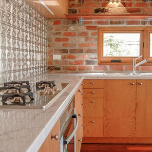 Photo of a small traditional l-shaped eat-in kitchen in Melbourne with a double-bowl sink, flat-panel cabinets, light wood cabinets, marble benchtops, metallic splashback, metal splashback, stainless steel appliances, dark hardwood floors, no island, brown floor and white benchtop.