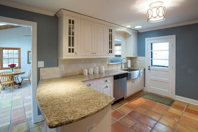Inspiration for a mid-sized timeless l-shaped terra-cotta tile eat-in kitchen remodel in DC Metro with a farmhouse sink, beaded inset cabinets, white cabinets, granite countertops, beige backsplash, travertine backsplash, stainless steel appliances and a peninsula