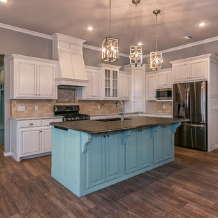 Mid-sized traditional eat-in kitchen inspiration - Mid-sized elegant l-shaped porcelain tile eat-in kitchen photo in Dallas with an undermount sink, brown backsplash, stainless steel appliances, an island, raised-panel cabinets, white cabinets, granite countertops and ceramic backsplash