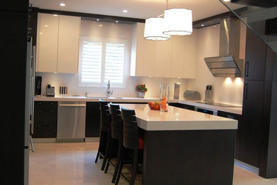Modern inredning av ett kök, med en undermonterad diskho, släta luckor, skåp i mörkt trä, bänkskiva i kvartsit, vitt stänkskydd, rostfria vitvaror och en köksö