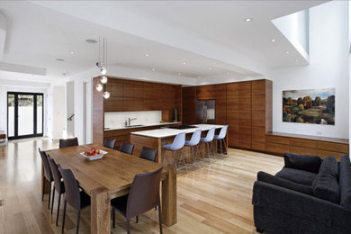 Example of a mid-sized trendy l-shaped light wood floor and brown floor open concept kitchen design in Toronto with an undermount sink, flat-panel cabinets, medium tone wood cabinets, quartzite countertops, white backsplash, stone slab backsplash, stainless steel appliances, an island and white countertops
