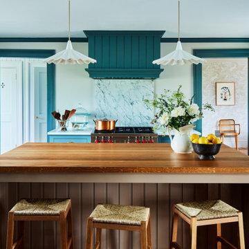 Teal Coastal Kitchen with large wooden island and Wolf Range