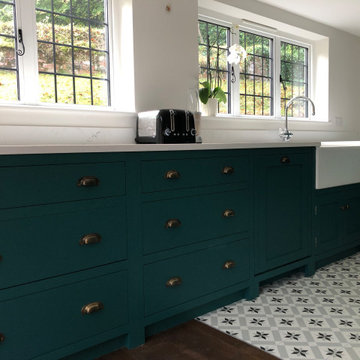 Teal green hand painted kitchen with large island and statement floor tiles