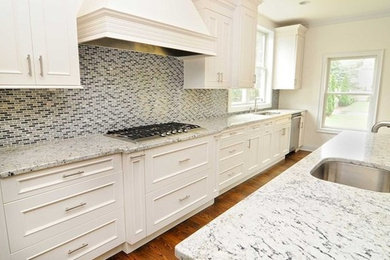 Example of a large transitional l-shaped medium tone wood floor and brown floor eat-in kitchen design in New York with shaker cabinets, white cabinets, granite countertops, multicolored backsplash, mosaic tile backsplash, stainless steel appliances, an island and an undermount sink