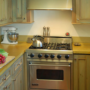 Inspiration for a small country u-shaped separate kitchen in San Luis Obispo with recessed-panel cabinets, green cabinets, concrete benchtops, yellow splashback, stainless steel appliances and terra-cotta floors.