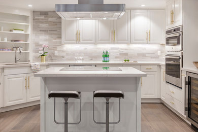 Idéer för ett mellanstort modernt vit kök, med en nedsänkt diskho, luckor med upphöjd panel, vita skåp, bänkskiva i kvarts, grått stänkskydd, stänkskydd i marmor, rostfria vitvaror, mellanmörkt trägolv, en köksö och brunt golv