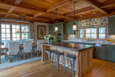 Exempel på ett rustikt linjärt kök och matrum, med en undermonterad diskho, luckor med profilerade fronter, gröna skåp, integrerade vitvaror, en köksö och ljust trägolv