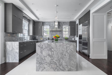 Example of a large trendy porcelain tile and white floor kitchen design in New York with an integrated sink, black cabinets, marble countertops, gray backsplash, stone slab backsplash and an island