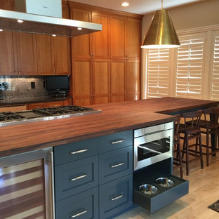 Foto di una cucina minimal di medie dimensioni con lavello sottopiano, ante in stile shaker, ante in legno scuro, top in legno, paraspruzzi verde, paraspruzzi in granito, elettrodomestici in acciaio inossidabile, parquet chiaro, isola, pavimento beige, top marrone e soffitto a volta