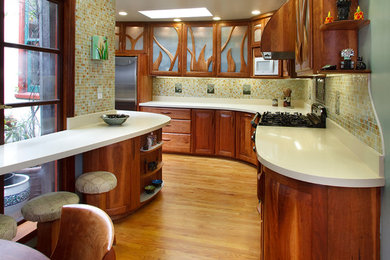 Eat-in kitchen - small eclectic galley medium tone wood floor and brown floor eat-in kitchen idea in San Francisco with raised-panel cabinets, medium tone wood cabinets, quartz countertops, white backsplash, glass tile backsplash, a double-bowl sink and colored appliances