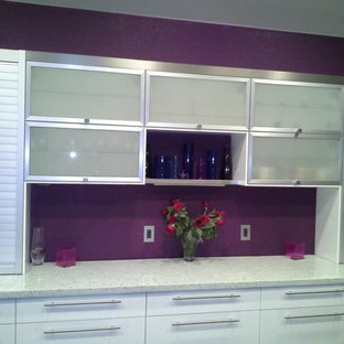 Photo of a large contemporary l-shaped eat-in kitchen in Austin with an undermount sink, glass-front cabinets, stainless steel cabinets, concrete benchtops, stainless steel appliances, concrete floors and with island.