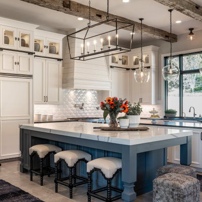 Country l-shaped gray floor kitchen photo with recessed-panel cabinets, white cabinets, white backsplash, paneled appliances, two islands and white countertops