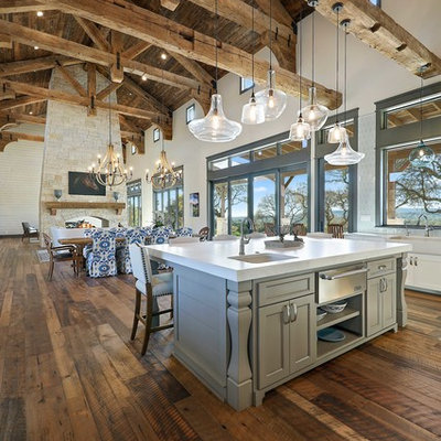 Inspiration for a rustic u-shaped medium tone wood floor and brown floor kitchen remodel in Austin with an undermount sink, recessed-panel cabinets, white cabinets, white backsplash, stainless steel appliances and an island