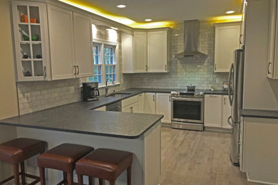 Small transitional u-shaped light wood floor and beige floor eat-in kitchen photo in Baltimore with a double-bowl sink, shaker cabinets, white cabinets, granite countertops, gray backsplash, marble backsplash, stainless steel appliances, a peninsula and gray countertops