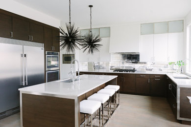 Example of a minimalist l-shaped light wood floor and beige floor open concept kitchen design in Chicago with an undermount sink, beaded inset cabinets, white cabinets, tile countertops, metallic backsplash, porcelain backsplash, stainless steel appliances, an island and white countertops