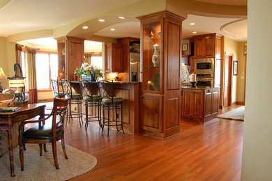 Foto på ett vintage kök, med skåp i mellenmörkt trä, granitbänkskiva, vitt stänkskydd, stänkskydd i keramik, rostfria vitvaror, mellanmörkt trägolv och en köksö