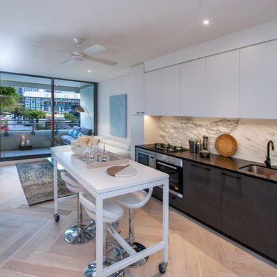 Inspiration for a mid-sized contemporary single-wall light wood floor open concept kitchen remodel in Sydney with an undermount sink, flat-panel cabinets, white cabinets, white backsplash, stainless steel appliances, an island, marble countertops and marble backsplash