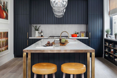 Esempio di una grande cucina chic con lavello sottopiano, ante blu, paraspruzzi grigio, paraspruzzi in gres porcellanato, elettrodomestici da incasso, pavimento grigio, top bianco e ante lisce
