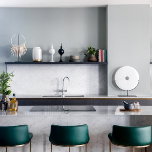 Inspiration för stora moderna vitt kök, med släta luckor, vitt stänkskydd, en köksö, en undermonterad diskho, skåp i mörkt trä, marmorbänkskiva, stänkskydd i marmor, rostfria vitvaror, ljust trägolv och grått golv