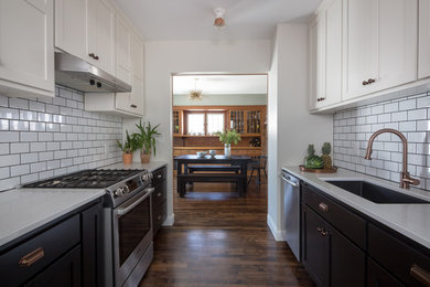 Example of a small arts and crafts galley dark wood floor eat-in kitchen design in Minneapolis with an undermount sink, shaker cabinets, quartz countertops, white backsplash and stainless steel appliances