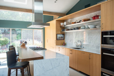 Example of a large trendy galley porcelain tile and gray floor eat-in kitchen design in Los Angeles with an undermount sink, flat-panel cabinets, medium tone wood cabinets, marble countertops, white backsplash, marble backsplash, stainless steel appliances, an island and white countertops