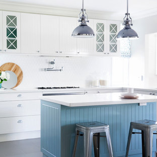 Mid-sized eat-in kitchen in Sydney with raised-panel cabinets, white cabinets, white splashback, stainless steel appliances and with island.
