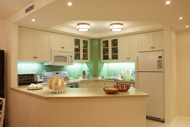 他の地域にある高級な中くらいなトロピカルスタイルのおしゃれなキッチン (シングルシンク、落し込みパネル扉のキャビネット、白いキャビネット、ソープストーンカウンター、緑のキッチンパネル、ボーダータイルのキッチンパネル、白い調理設備、セラミックタイルの床) の写真