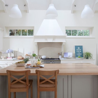 Kitchen - traditional kitchen idea in Dublin with recessed-panel cabinets, white cabinets and wood countertops