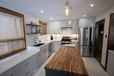 Mid-sized minimalist l-shaped porcelain tile and white floor eat-in kitchen photo in Other with an undermount sink, flat-panel cabinets, light wood cabinets, wood countertops, white backsplash, ceramic backsplash, stainless steel appliances, an island and multicolored countertops