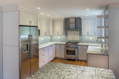Kitchen - mid-sized contemporary u-shaped medium tone wood floor and brown floor kitchen idea in Wilmington with a farmhouse sink, shaker cabinets, white cabinets, quartzite countertops, green backsplash, subway tile backsplash, stainless steel appliances, an island and multicolored countertops