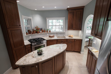 Enclosed kitchen - large traditional single-wall porcelain tile and white floor enclosed kitchen idea in Miami with an undermount sink, raised-panel cabinets, dark wood cabinets, granite countertops, beige backsplash and an island