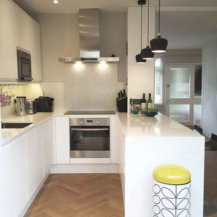 Kleine Skandinavische Wohnküche in U-Form mit flächenbündigen Schrankfronten, weißen Schränken, Arbeitsplatte aus Terrazzo, Kücheninsel und weißer Arbeitsplatte in London
