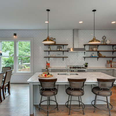 Example of a cottage l-shaped dark wood floor and brown floor eat-in kitchen design in Atlanta with an undermount sink, shaker cabinets, gray cabinets, white backsplash, subway tile backsplash, stainless steel appliances and an island