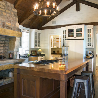 Kitchen - rustic kitchen idea in Atlanta with glass-front cabinets, a farmhouse sink, white cabinets and wood countertops