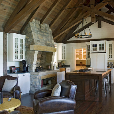 Mountain style open concept kitchen photo in Atlanta with wood countertops, a farmhouse sink, glass-front cabinets, white cabinets and paneled appliances